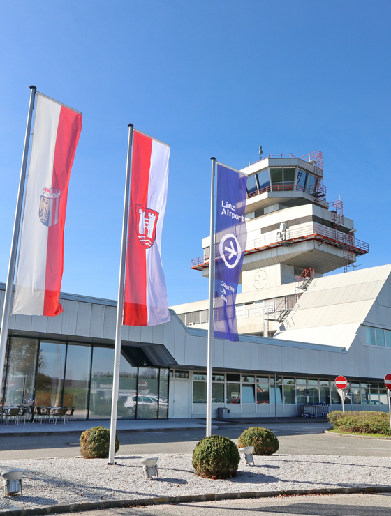 Vorderfront Flughafen mit Tower und Fahnen | © Flughafen Linz