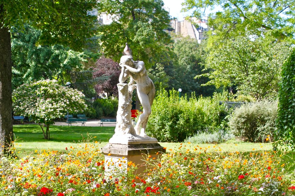 Nackte Damenstatue in blühendem Garten | © Unsplash