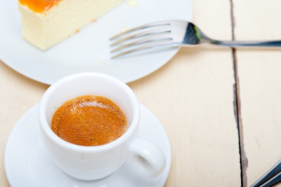 Tasse Espresso mit Kuchenstück auf Tischplatte | © Envato Elements