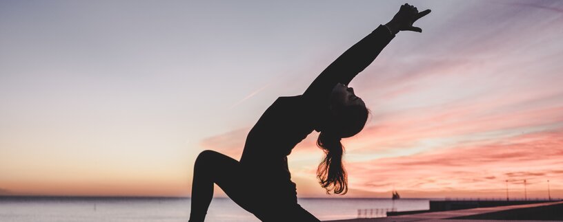 Silhouette einer Frau bei Yogaübungen am Strand | © Photo by <a href="https://unsplash.com/@kikekiks?utm_source=unsplash&utm_medium=referral&utm_content=creditCopyText">kike vega</a> on <a href="https://unsplash.com/?utm_source=unsplash&utm_medium=referral&utm_content=creditCopyText">Unsplash</a>   