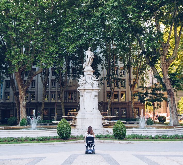 Frau im Rollstuhl vor Brunnen mit Statue | © Carlos Navas Unsplash