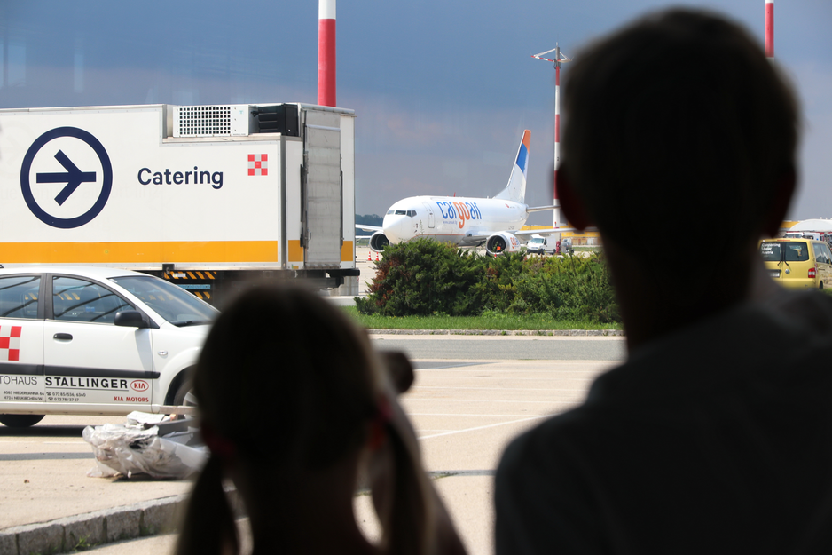 Geschwisterpaar vor der Glasfront im Transitbereich | © Linz Airport