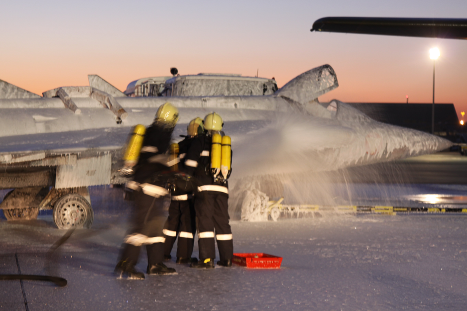 Feuerwehrmänner besprühen Kampfjet mit Schaum bei Übung | © Linz Airport