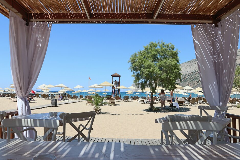 Blick unter Pavillon auf Liegen und Strand auf Kreta | © Linz Airport