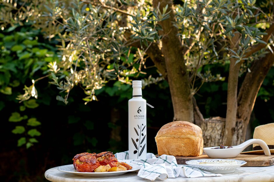 Tisch mit Oliven, Olivenöl und Brot unter Olivenbaum | © Unsplash