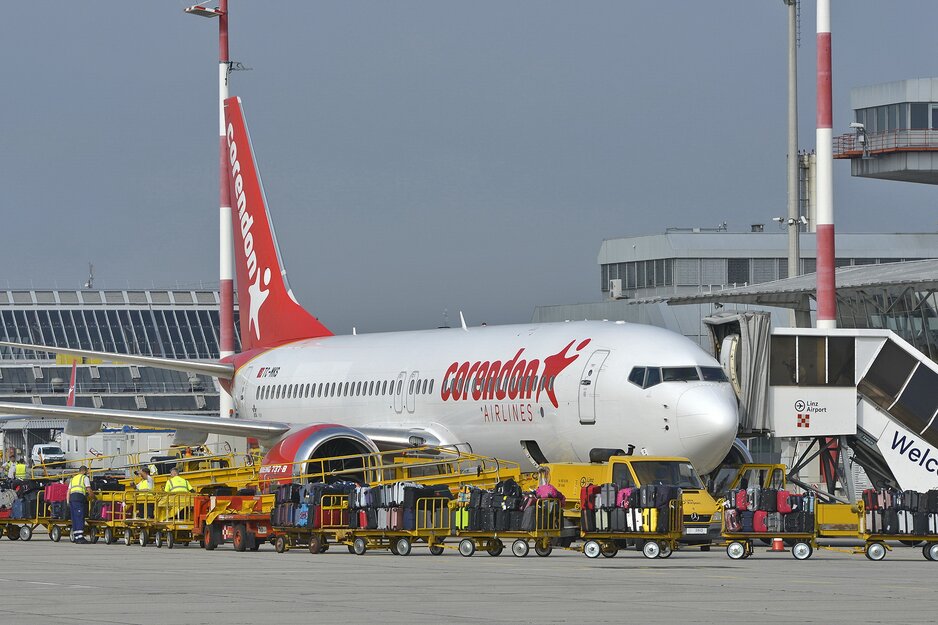 Corendonmaschine bei der Abfertigung mit vollen Koffertrolleys im Vordergrund | © Flughafen Linz