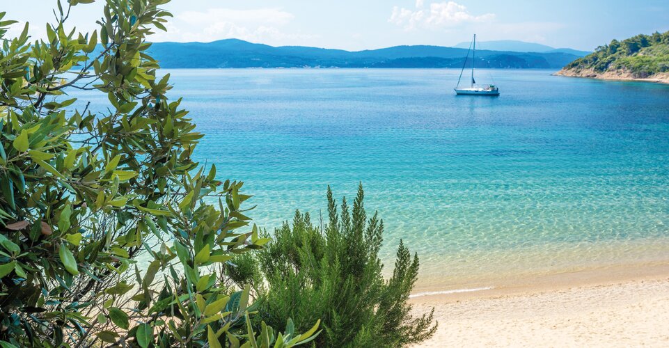 Agia Eleni Strand mit Blick auf Boot im Meer auf Skiathos | © Springer Reisen